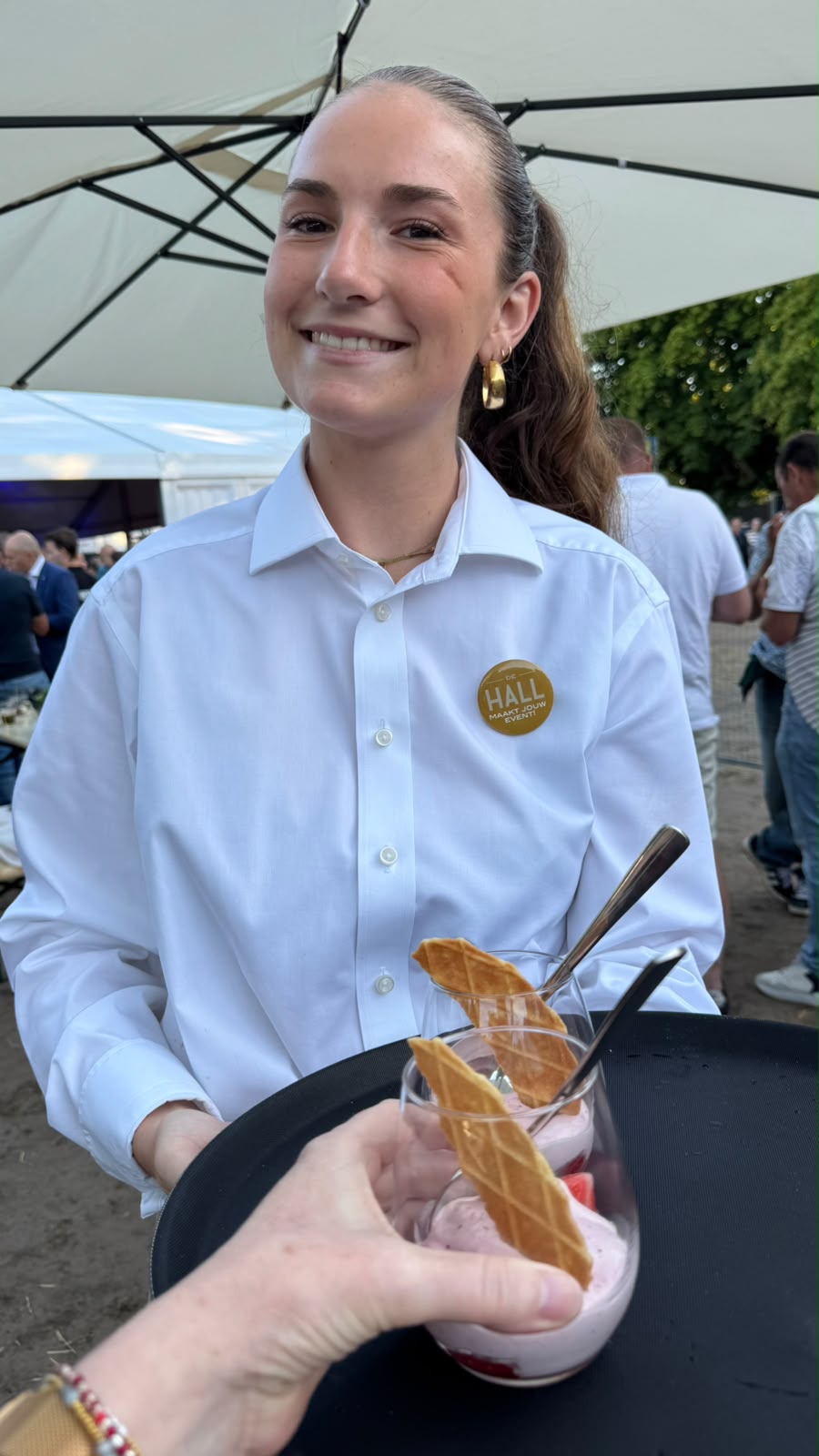 Medewerker van de HALL serveert een hapje